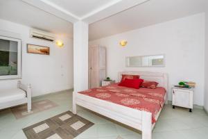 a bedroom with a bed with red pillows on it at Apartmani LIRA in Sutomore