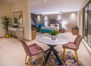 a living room with a bed and a table and chairs at The Address Palace Apartments in Dammam