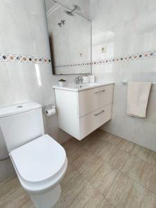 a white bathroom with a toilet and a sink at Park Beach La Mata in La Mata