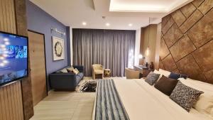 een hotelkamer met een bed en een flatscreen-tv bij THE POOL LABONE in Accra