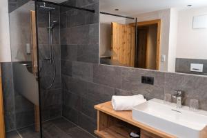 uma casa de banho com um lavatório e um chuveiro em Edelweiss Chalet im Sommer inklusive Super Sommer Card em Ladis