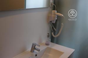 a bathroom with a sink and a phone on the wall at ARTiSTiC GUESTHOUSE in Tomar