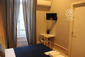 a bedroom with a bed and a table and a window at ARTiSTiC GUESTHOUSE in Tomar