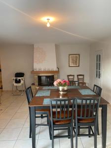 uma sala de jantar com mesa e cadeiras em Vendée - Maison de Vacances em La Genétouze