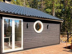 un grand bâtiment avec une fenêtre ronde sur une terrasse dans l'établissement 4 person holiday home in GARPHYTTAN, à Garphyttan