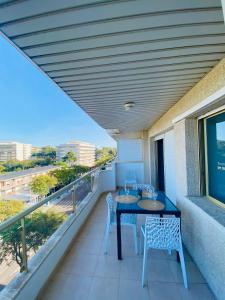 einen Balkon mit einem Tisch und Stühlen auf einem Gebäude in der Unterkunft ARQUUS APARTMENT SALOU BEACH in Salou