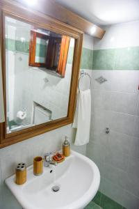 a bathroom with a white sink and a mirror at ΔΗΜΗΤΣΑΝΑΣ ΤΟΠΟΣ Νύμφη Νέδα in Dhimitsana