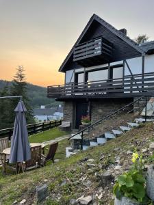 ein Haus auf einem Hügel mit Terrasse und Sonnenschirm in der Unterkunft Ferienhaus Sonnendeck in Simmerath