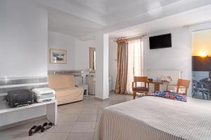 a hotel room with a bed and a living room at Hotel Lido Thassos in Limenas