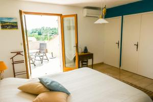 1 dormitorio con cama y vistas a un patio en Chambre d hôtes de la Louve en Fréjus