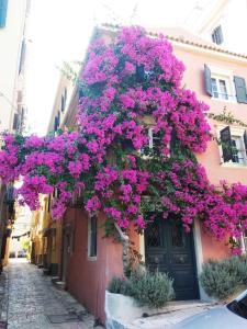 a building with purple flowers on the side of it at Corfu Mariú Suite by Liston in Corfu