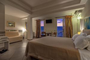 a bedroom with a bed and a living room at Hotel Lido Thassos in Limenas