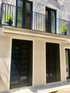 twee garagedeuren op een gebouw met een balkon bij LOFT DE DISEÑO CON BALCON in Figueres
