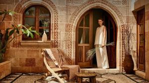 un homme debout à l'entrée d'un bâtiment dans l'établissement AF Lindia Nature Design Hotel, à Lindos