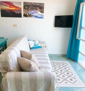 a living room with a couch and a tv at Capo Testa Vista Mare in Santa Teresa Gallura