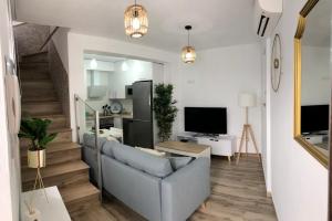 a living room with a couch and a television at Cerezo's House - Terrace & Jacuzzi in Frigiliana