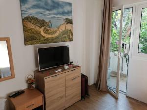 ein Wohnzimmer mit einem Flachbild-TV auf einer Kommode in der Unterkunft Candy apartment central location Bečići in Becici