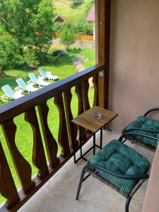 d'un balcon avec une table et des chaises et une vue sur la cour. dans l'établissement Pensiunea Anotimpuri by Casa Sandu, à Bran