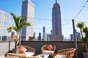 a patio with chairs and a table with a view of the city at Hotel Hendricks in New York
