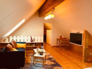 a living room with a couch and a tv at Neizhig Koad Petit Nid en Bois in Péaule