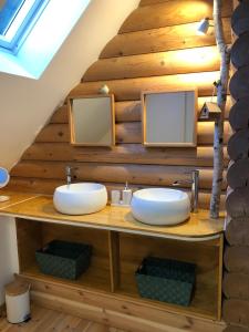 a bathroom with two sinks on a wooden wall at Neizhig Koad Petit Nid en Bois in Péaule