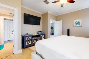 1 dormitorio con 1 cama y TV de pantalla plana en Sun Dancer #1 en South Padre Island