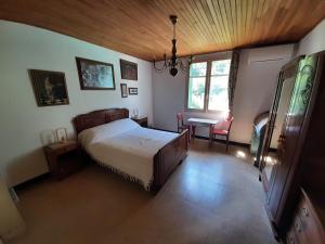 a bedroom with a bed and a desk and a window at Les Chambres Chouettes in Villefranche-de-Conflent