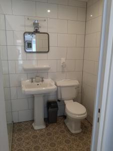 a bathroom with a toilet and a sink and a mirror at Les Chambres Chouettes in Villefranche-de-Conflent