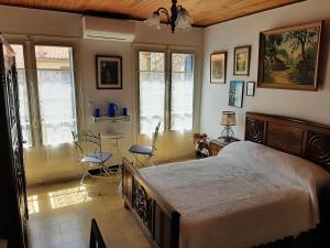 a bedroom with a bed and a table and chairs at Les Chambres Chouettes in Villefranche-de-Conflent