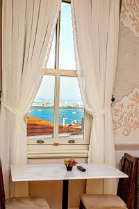 una finestra con tavolo e vista sull'oceano di Meroddi Barnathan Hotel a Istanbul