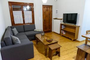 a living room with a couch and a tv at ΔΗΜΗΤΣΑΝΑΣ ΤΟΠΟΣ Νύμφη Αγνώ in Dimitsana