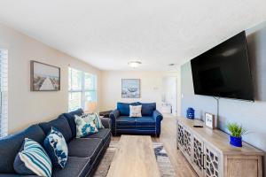 a living room with a couch and a flat screen tv at Pinellas Park Cottage in St Petersburg