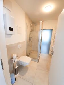ein Bad mit einer Dusche und einem WC in der Unterkunft PB Ferienwohnungen - FeWo 6 - Stilvoll eingerichtetes Apartment im Herzen Senftenbergs in Senftenberg