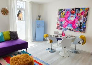 ein Wohnzimmer mit einem Tisch, Stühlen und einem Gemälde in der Unterkunft PB Ferienwohnungen - FeWo 6 - Stilvoll eingerichtetes Apartment im Herzen Senftenbergs in Senftenberg