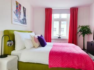 ein Schlafzimmer mit einem großen Bett mit einer rosa Decke in der Unterkunft PB Ferienwohnungen - FeWo 6 - Stilvoll eingerichtetes Apartment im Herzen Senftenbergs in Senftenberg