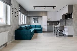 een woonkamer met een blauwe bank en een keuken bij Magic Apart 10 in Lviv