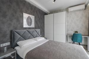 a bedroom with a large bed and a blue chair at Magic Apart 10 in Lviv