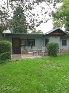 ein Haus mit einer Terrasse mit einem Tisch und Stühlen in der Unterkunft Waldesruh Strausberg in Strausberg