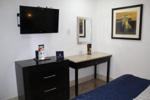 a bedroom with a desk and a tv on the wall at Capital Urban in Los Mochis