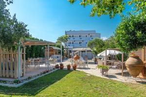 a patio with tables and chairs in a yard at Hotel Lido Thassos in Limenas