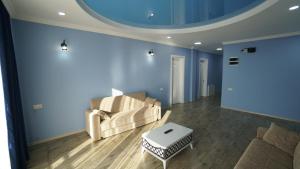 a living room with blue walls and a couch and a table at Guest House ETM in Makhinjauri