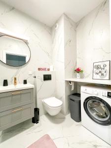uma casa de banho com um lavatório e uma máquina de lavar roupa em SuperApart Omulewska em Varsóvia