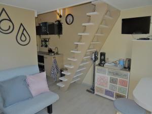 a living room with a staircase with a couch and a table at B&B Het Onderduukertje in Wemeldinge
