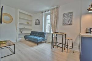ein Wohnzimmer mit einem blauen Sofa und einem Tisch in der Unterkunft Le SWEETHOME in Épernon