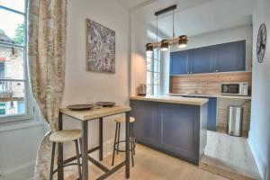 eine Küche mit blauen Schränken und Barhockern in der Unterkunft Le SWEETHOME in Épernon