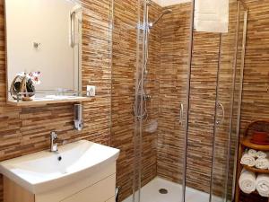 a bathroom with a sink and a glass shower at Studio Piata Mare apartments in Sibiu