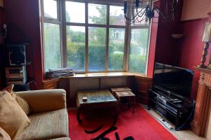 a living room with a couch and a large window at Cosy 2 bed house near Peak District in Greenhill