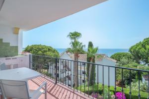 balkon ze stołem i widokiem na ocean w obiekcie Beach Apartment Las Acacias Torrenueva w mieście La Cala de Mijas