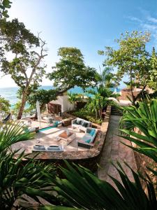 an outdoor patio with lounge chairs and the ocean at Aria By LD Hotel Boutique in Pampatar