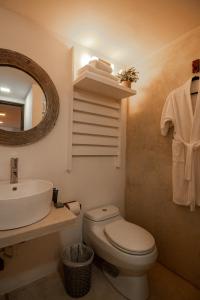 a bathroom with a toilet and a sink and a mirror at Aria By LD Hotel Boutique in Pampatar +27 photos